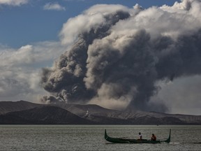 A fishing boat sails along a lake as Taal Volcano erupts on Jan. 14, 2020 in Talisay, Batangas province, Philippines. (Ezra Acayan/Getty Images)