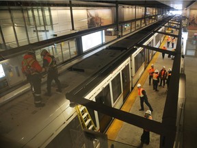 Workers mull over repairs to the broken down light-rail system recently.