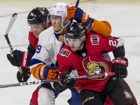 Defencemen Dylan DeMelo (right) and Mark Borowiecki, here sandwiching Islanders’ Brock Nelson, are among the most attractive trade chips the Senators have. That is, if the team doesn’t see one or both as valuable pieces in the rebuild to try and re-sign.  Errol McGihon/Ottawa Sun