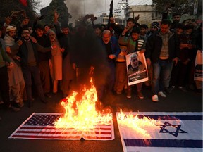 Protesters burn U.S. and Israel flags as they shout slogans against the United States during a demonstration following a U.S. airstrike that killed top Iranian commander Qasem Soleimani in Iraq, in Lahore on Jan. 3, 2020.
