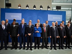 (Front row, L to R) Britain's Prime Minister Boris Johnson, Congolese President Denis Sassou Nguesso , Turkish President Recep Tayyip Erdogan, French President Emmanuel Macron, German Chancellor Angela Merkel, Secretary-General of the United Nations (UN) Antonio Guterres, Russian President Vladimir Putin, Egyptian President Abdul Fattah al-Sisi and Algerian president Abdelmadjid Tebboune, (second row, L to R) arab League Secretary General Ahmed Abul Gheit, African Union (AU) Committee Chairman Moussa Faki, European Council President Charles Michel, German Foreign Minister Heiko Maas, US Secretary of State Mike Pompeo, member of China's political bureau Yang Jiechi, President of the European Commission Ursula von der Leyen, European Union High Representative for Foreign Affairs and Security Policy Josep Borrell, Italian Prime Minister Giuseppe Conte and United Arab Emirates Foreign Minister Sheikh Abdullah bin Zayed Al Nahyan pose for a family picture during a Peace summit on Libya at the Chancellery in Berlin, on January 19, 2020. -