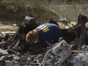 This still image taken from a January 27, 2020,video released by the National Transportation Safety Board (NTSB), shows a NTSB official inspecting the remains of a helicopter which crashed near Calabasa, California, on January 26, 2020, killing retired NBA star Kobe Bryant, his daughter, Gianna, and seven others.