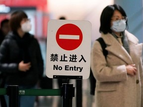 Passengers wearing masks are seen at Hongqiao International Airport in Shanghai, China on Monday.
