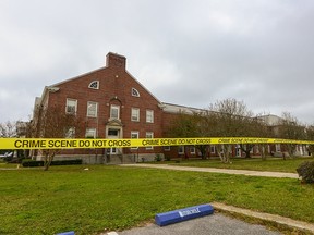 This file handout photo released on December 7, 2019 by the FBI shows police tape stretching across a street near a building after a shooting incident at a naval base in Pensacola, Florida on December 6, 2019.