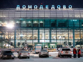 In this Feb. 11, 2018, file photo, emergency personnel stand next to an emergency vehicle parked in front of the Domodedovo International Airport outside Moscow.