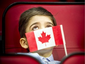 Seven-year-old Karam Alokel holds his Canadian flag during a citizenship ceremony before an Ottawa Senators game at the Canadian Tire Centre on Jan. 18, 2020.