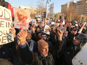 Iranian demonstrators hold placards bearing the image of slain military commander Qasem Soleimani in front of the British embassy in the capital Tehran on Sunday following the British ambassador's arrest for allegedly attending an illegal demonstration.