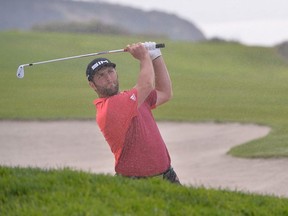 Jon Rahm plays his second shot from a fairway bunker on the fourth hole during the second round of the Farmers Insurance Open golf tournament at Torrey Pines Municipal Golf Course - South Course.