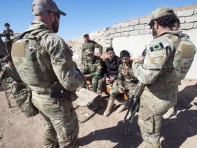 File photo from 2017 of Canadian special forces soldiers, left and right, speak with Peshmerga fighters at an observation post, Monday, February 20, 2017 in northern Iraq.
