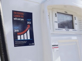 A gas pump displays an anti-carbon tax sticker. Liberal staffers are peeling government-mandated anti-carbon tax stickers off of gas pumps, Ontario Energy Minister Greg Rickford said Tuesday, insisting that disappearing decals are not the result of faulty glue.