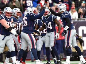 Patriots quarterback Tom Brady (right) high fives offensive tackle Isaiah Wynn (76) after a touchdown by running back James White (not pictured) during second half NFL action at Gillette Stadium in Foxborough, Mass., on Dec. 29, 2019.