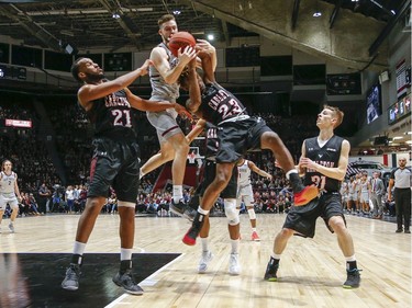 Gee Gee player Gage Sabean and Raven Stanley Mayambo battle for the ball in the men's Capital Hoops Classic basketball game between the University of Ottawa and Carleton University.