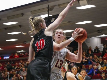 Angela Ribarich takes a shot with Raven Emma Kiesekamp defending in the women's Capital Hoops Classic basketball game between the University of Ottawa and Carleton University.