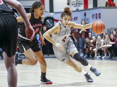 Brooklynn McAlear-Fanus of the Gee-Gee's drives past Tatyanna Burke in the women's Capital Hoops Classic basketball game between the University of Ottawa and Carleton University.