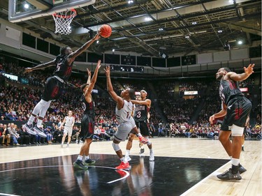 Munis Tutu goes high in the air to block the shot by Gee Gee's Kevin Civil in the men's Capital Hoops Classic basketball game between the University of Ottawa and Carleton University.