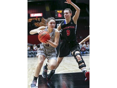 Natsuki Szczokin of the Gee Gee's drives around Madison Reid in the women's Capital Hoops Classic basketball game between the University of Ottawa and Carleton University.