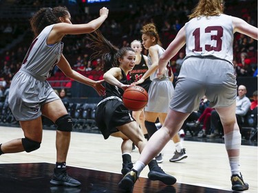 Ravens player Kali Pocrnic is surrounded by Gee Gee's as she drives for the net in the women's Capital Hoops Classic basketball game between the University of Ottawa and Carleton University.