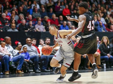 Calvin Epistola of Ottawa collisdes with Alain Louis in the men's Capital Hoops Classic basketball game between the University of Ottawa and Carleton University