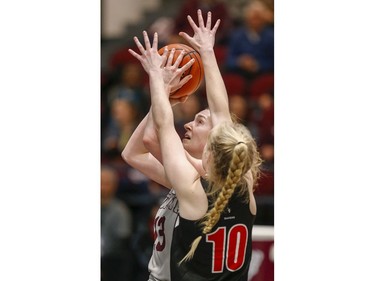 Angela Ribarich takes a shot with Raven Emma Kiesekamp defending in the women's Capital Hoops Classic basketball game between the University of Ottawa and Carleton University.