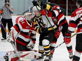 Kingston's Jordan Frasca battles for control of the puck in front of Ottawa goalie Will Cranley during Tuesday's game at the TD Place arena.