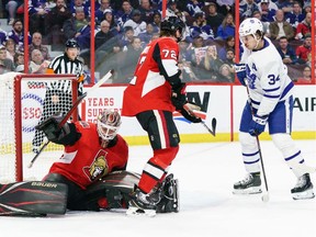 Marcus Hogberg of the Ottawa Senators makes a save against Auston Matthews of the Toronto Maple Leafs as Thomas Chabot defends the net in the first period at Canadian Tire Centre on Saturday, Feb. 15, 2020.