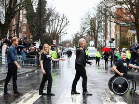 Prince Harry, Duke of Sussex and two members of the Invictus Games choir pose on the famous zebra crossing that The Beetles walked across at Abbey Road Studios on February 28, 2020 in London, England.
