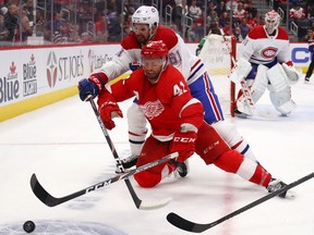 Luke Glendening of the Detroit Red Wings battles for the puck with Xavier Ouellet of the Montreal Canadiens during a game on Feb. 18, 2020.