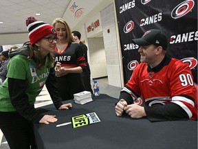 David Ayres signs autographs for fans during the game between the Dallas Stars and Carolina Hurricanes at PNC Arena in Raleigh on Tuesday.