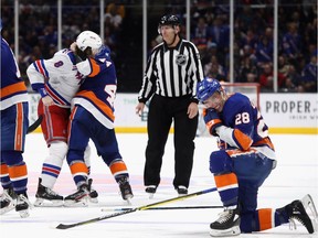 Jean-Gabriel Pageau of the Islanders fights with the Rangers' Jacob Trouba, who had just delivered a high hit against Islanders teammate Michael Dal Colle (28).