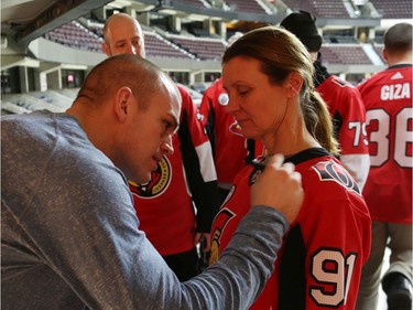 Mark Borowiecki signs Debbie Hynes' jersey during a Soldier On event at the Canadian Tire Centre in Ottawa, February 03, 2020.  In partnership with the Canadian Forces' Soldier On Program, the Senators Alumni will host a two-day camp at Canadian Tire Centre in support of ill and injured veterans beginning Monday morning. On Monday, Feb. 3, a group of ill and injured veterans from the Canadian Forces (CF) Soldier On Program will arrive at Canadian Tire Centre for a two-day camp with the Senators Alumni.  Photo by Jean Levac/Postmedia News assignment 133187
