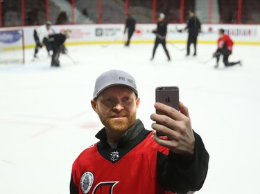 Kenny White takes a selfie with the Ottawa Senators in the background during a Soldier On event at the Canadian Tire Centre in Ottawa, February 03, 2020.  In partnership with the Canadian Forces' Soldier On Program, the Senators Alumni will host a two-day camp at Canadian Tire Centre in support of ill and injured veterans beginning Monday morning. On Monday, Feb. 3, a group of ill and injured veterans from the Canadian Forces (CF) Soldier On Program will arrive at Canadian Tire Centre for a two-day camp with the Senators Alumni.  Photo by Jean Levac/Postmedia News assignment 133187