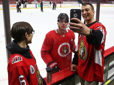Stephen Giza takes a selfie with Mike Reilly of the Ottawa Senators as Jessica Dajko (L) looks on during a Soldier On event at the Canadian Tire Centre in Ottawa, February 03, 2020.  In partnership with the Canadian Forces' Soldier On Program, the Senators Alumni will host a two-day camp at Canadian Tire Centre in support of ill and injured veterans beginning Monday morning. On Monday, Feb. 3, a group of ill and injured veterans from the Canadian Forces (CF) Soldier On Program will arrive at Canadian Tire Centre for a two-day camp with the Senators Alumni.