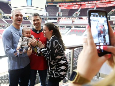 Mark Borowiecki holds Damien Bouchard, 9 months old, as he starts crying and the parents Pierre-Luc Bouchard  and Émilie Éthier (R) laugh during a photo at the Canadian Tire Centre in Ottawa, February 03, 2020.  In partnership with the Canadian Forces' Soldier On Program, the Senators Alumni will host a two-day camp at Canadian Tire Centre in support of ill and injured veterans beginning Monday morning. On Monday, Feb. 3, a group of ill and injured veterans from the Canadian Forces (CF) Soldier On Program will arrive at Canadian Tire Centre for a two-day camp with the Senators Alumni.  Photo by Jean Levac/Postmedia News assignment 133187