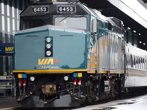 A VIA Rail employee stands on the platform next to a F40 locomotive at the train station in Ottawa. (THE CANADIAN PRESS)