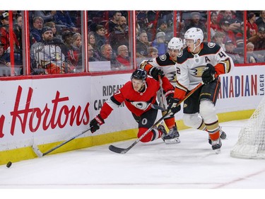 Brady Tkachuk (left) is sent to the ice by Cam Fowler (centre) and Josh Manson moving in in the first period as the Ottawa Senators take on the Anaheim Ducks in NHL action at the Canadian Tire Centre in Ottawa.