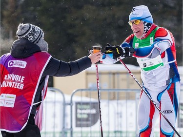 Robert Faltus grabs a drink from a volunteer during the 27 km Classic event at the Gatineau Loppet. February 15, 2020. Errol McGihon/Postmedia