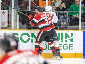 File photo/ Ottawa 67's Austen Keating and Thomas Stevenson of the Windsor Spitfires are up against the boards on Sunday.