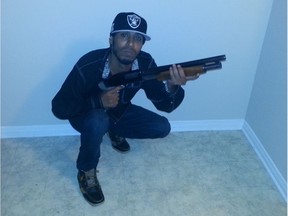 Talal Al-Shammari in Raiders cap poses with a guns at Alam Buoc's apartment on July 24, 2016.