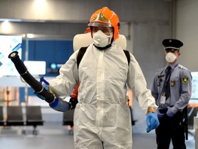 A disinfection worker of Budapest's Liszt Ferenc Airport of arrives with a sprayer machine on Feb. 5, 2020 during a presentation for the press. (ATTILA KISBENEDEK/AFP via Getty Images)