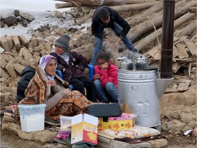 Locals gather around a stove in Baskale, in the Van province, after a magnitude 5.7 earthquake in northwestern Iran killed at least nine people in neighbouring Turkey and injured dozens more on both sides of the border, authorities said. Photo by Demiroren News Agency