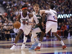 Raptors guard Terence Davis drives to the basket as forward Rondae Hollis-Jefferson provides a screen on Bucks guard Donte DiVincenzo during the first half of Tuesday's contest in Toronto.