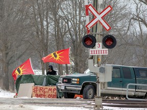 A man smokes at the site of a rail stoppage on Tyendinaga Mohawk Territory, as part of a protest against British Columbia's Coastal GasLink pipeline, in Tyendinaga February 16, 2020. (REUTERS/Carlos Osorio/File Photo)