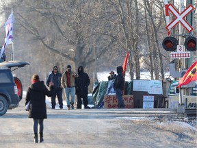 First Nations members, supporting the Wet'suwet'en Nation who are trying to stop the construction of British Columbia's Coastal GasLink pipeline, gesture to an approaching reporter to stop approaching their camp on Tyendinaga Mohawk Territory in Tyendinaga, Ontario, Canada February 24, 2020. REUTERS/Chris Helgren