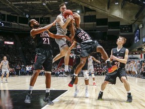 Gee-Gees’ Gage Sabean (left) and Ravens’ Stanley Mayambo battle for the ball in the men’s Capital Hoops Classic 
between the University of Ottawa and Carleton University Friday night. The Gee-Gees’ men won 68-67. Wayne Cuddington/Ottawa Sun