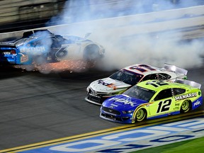 Denny Hamlin (11) and Ryan Blaney (12) race to the finish as Ryan Newman wrecks on the last lap of the Daytona 500 at Daytona International Speedway on February 17, 2020 in Daytona Beach, Florida.