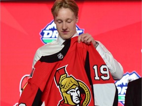 Lassi Thomson puts on a jersey after being selected as the number nineteen overall pick to the Ottawa Senators in the first round of the 2019 NHL Draft at Rogers Arena.