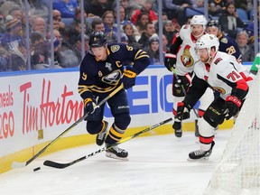 Buffalo Sabres center Jack Eichel carries the puck behind the net as Ottawa Senators center Chris Tierney tries to defend, Jan. 28, 2020.