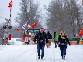 Ontario Provincial Police officers leave after a brief meeting with representatives of the Mohawk Nation at the site of a rail stoppage on Tyendinaga Mohawk Territory on Saturday.