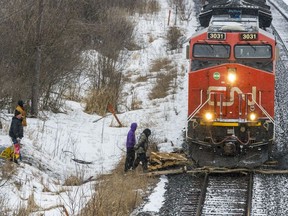 A CN Railway train pushes through wooden pallets protestors placed in its way.