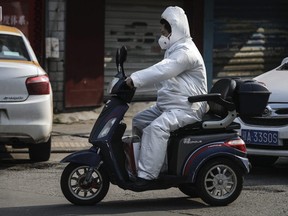 A man wears a protective mask while riding a scooter on in Wuhan, Hubei province, China, on Wednesday, Feb. 5, 2020.